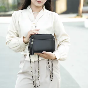 Classic black pebbled leather crossbody bag for women, featuring elegant chain strap and tassel.