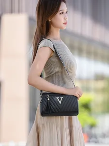 Stylish women's cylindrical shoulder bag, black crossbody purse with chevron design and metal V logo.