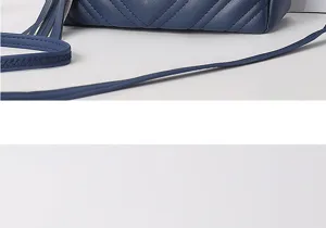 Detail view of blue quilted leather crossbody bag with chevron stitching and strap.