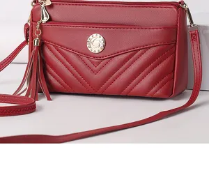 Red soft leather crossbody bag detail showcasing multi-layer design, tassel and quilted texture.