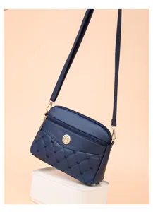 Close-up of a stylish dark blue PU leather crossbody bag with cute quilted heart embroidery.