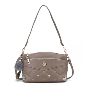 Stylish grey multi-layer quilted crossbody bag with cute pom-pom pendant and shoulder strap.
