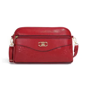 Detailed close-up of red multi-layer leather crossbody bag with stylish metal hardware.