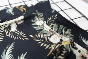 Detailed close-up view of Hawaiian tropical leaf print pet dog shirt fabric and button