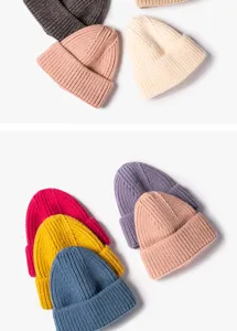 Winter knitted beanie hat detail showing various solid color warm wool caps for cold weather.