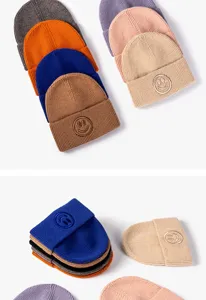 Detalle de gorro de punto con textura suave y bonito parche de sonrisa en varios colores.