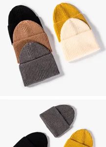 Close up view of cozy winter knitted beanies in multiple solid colors, soft ribbed texture.