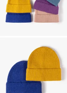 Close-up detail shot of colorful knitted beanies with rolled edge design for winter warmth.