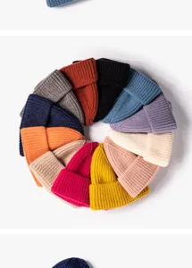 Detailed view of colorful knit beanies arranged in a circle, soft winter thermal wool material.