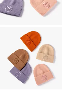 Primer plano detallado de gorros de punto coloridos con cara sonriente bordada bonita.