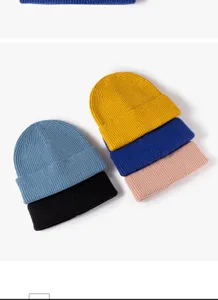 Detail shot of multiple colors rolled edge knitted beanies winter warm wool caps stacked neatly.