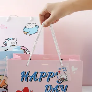 Pink paper gift bag with cute dog cartoon, sturdy handles and decorative tag for party favors.