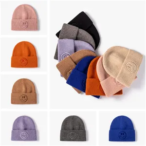 Solid color knitted beanie hat for women and men, warm winter cap with cute embroidered smiley patch.