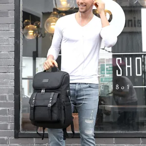 Detailansicht des schwarzen Vintage-Rucksacks mit USB-Anschluss und praktischen Fächern.