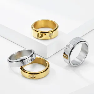 Detailopname van roestvrijstalen spinnerringen met micro-geplaveid kruisdetail op witte rekwisieten.