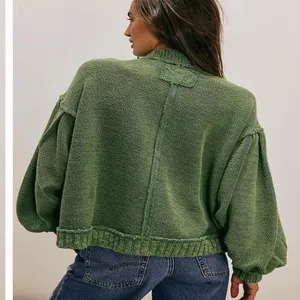 Green vintage knit cardigan detail showing stand collar, distressed seams, and lantern sleeves.