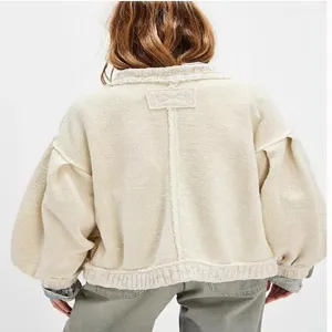 Back detail view of women vintage knit cardigan, featuring puff sleeves and raw seam lines.