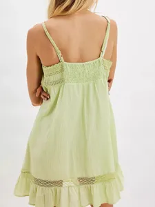 Vue dos d'une mini robe nuisette vert clair avec détails en dentelle et ourlet volanté.