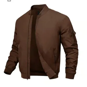 Détail de blouson aviateur marron avec fermeture éclair avant, poche de manche et col côtelé.