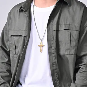 Close-up detail of the two-tone titanium steel cross necklace worn by model.