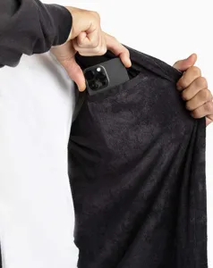 Interior pocket detail of black plush hooded changing robe, showing convenient phone storage design.