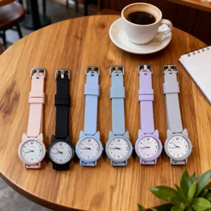 Vista dettagliata di orologi in silicone colorato con quadranti gatto su tavolo in legno.