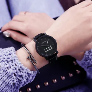 Gedetailleerd close-up van een zwart minimalistisch quartz horloge met grote wijzerplaat.