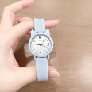 Dettaglio di un grazioso orologio al quarzo azzurro con orecchie di gatto e quadrante bianco.
