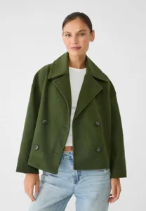 Close up view of the olive green wool double breasted short coat with lapel collar.