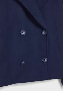 Detail view of a navy blue woolen double-breasted blazer showing buttons and lapel texture.