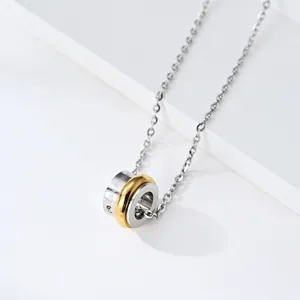 Gros plan détaillé du collier pendentif à double anneau rotatif en argent et or.