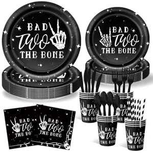 Black skeleton party tableware set with paper plates, cups, napkins and cutlery.
