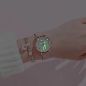 Detail shot of a pink leather strap quartz watch with glowing heart hands and numbers.