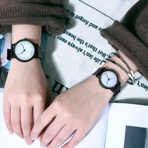 Close-up of minimalist couple black and white wristwatches worn on hands with details.