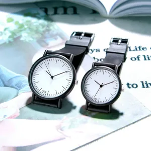 Minimalist couple quartz watches detail view with white dials and black straps.