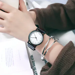 Minimalist black and white wristwatch detail shot, featuring clean dial design and slim strap.