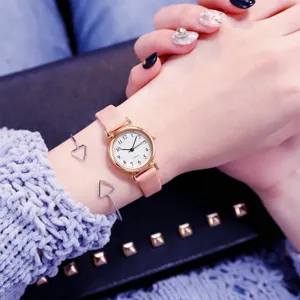 Montre quartz pour femme avec bracelet rose et petit cadran blanc, style mode minimaliste.