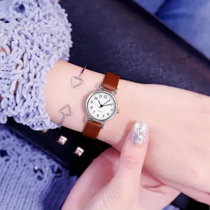 Minimalist vintage women quartz watch with brown leather strap and stylish silver bracelets.