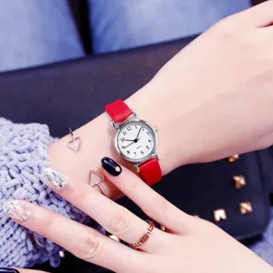 Close-up detail of women red leather strap retro quartz watch with minimalist dial.