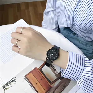 Gros plan détail montre quartz noire minimaliste avec cadran élégant et bracelet stylé.
