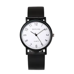 Detailed close-up of a minimalist quartz watch with white dial, black numerals and black strap.