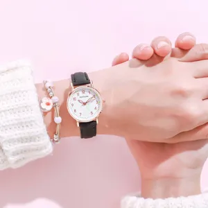 Cute student quartz watch with black leather strap and heart dial detail close up view.