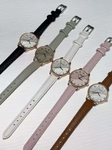 Minimalist quartz watch detail showing multiple leather strap color options and textured dials.