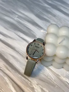 Minimalist green leather strap quartz watch with textured dial for women detail shot