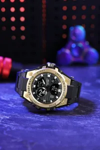 Detailed close-up of men's dual-display sports electronic watch with gold bezel and black band.