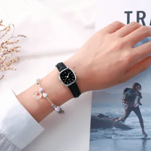Nahaufnahme einer minimalistischen kleinen quadratischen Quarzuhr mit Lederarmband.
