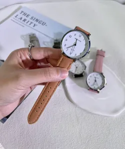 Minimalist quartz watch for students with brown leather strap and clear white dial.