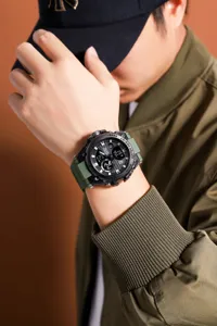 Close-up detail shot of men's tactical sports electronic watch with green strap on wrist.