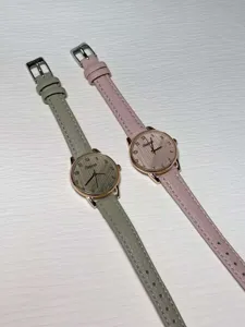 Detailed close-up of minimalist women watches with leather straps in grey and pink. Elegant design.