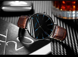 Men quartz watch detail view, black dial with blue markers and brown leather strap.